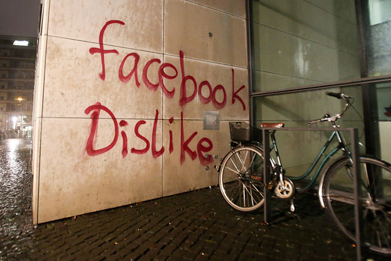 epa05067200 Unknown assailants deface the facade of a building housing the offices of Facebook Germany in Hamburg City, Hamburg, Germany, late 12 December 2015. The perpetrators had thrown paint bombs, broke windows and sprayed-painted the word 'Facebook Dislike' on a wall of the building. EPA/BODO MARKS