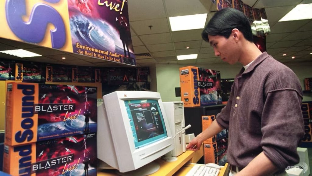 Zákazník si prehráva hudbu s pomocou vystavenej karty Sound Blaster, v obchode s PC hardvérom v Singapure