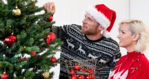 Žena s mužom vešajú ozdoby na vianočný stromček