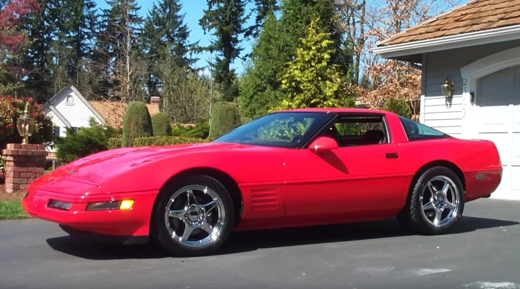 Červený športový automobil Chevrolet Corvette zaparkovaný pred domom